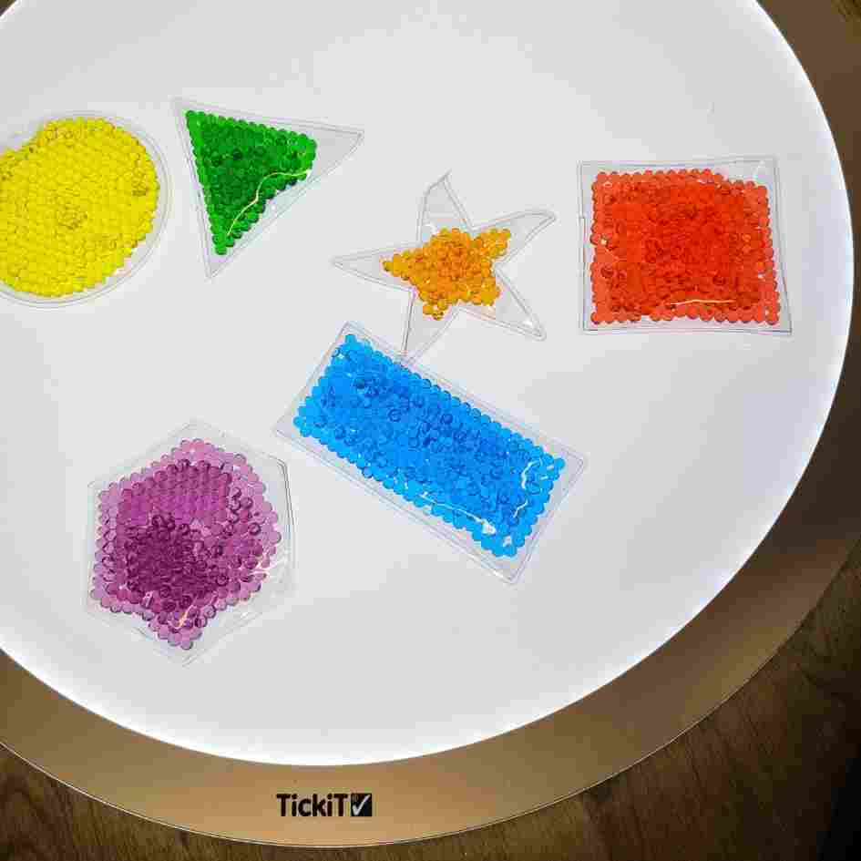 light box with shapes filled with coloured beads